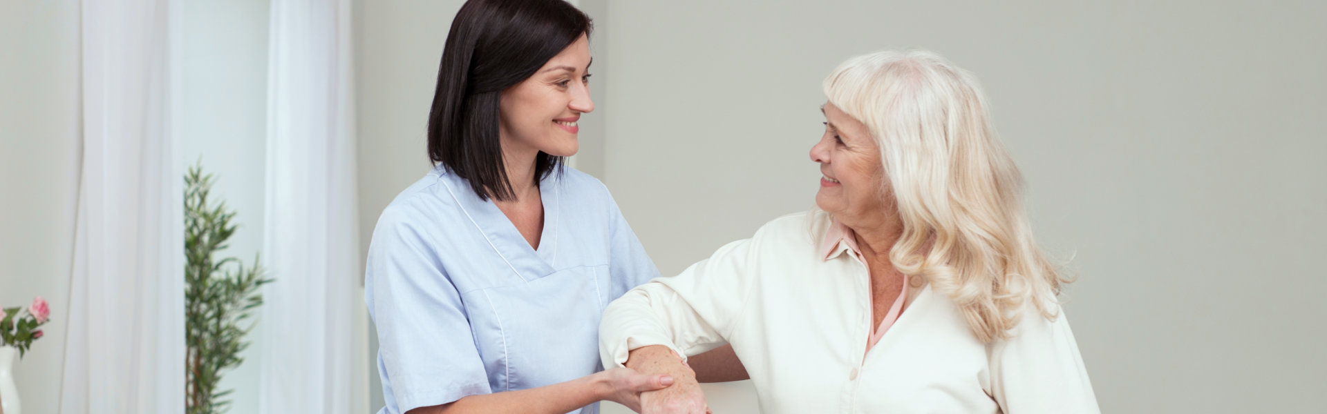 caregiver holding the senior woman's arm