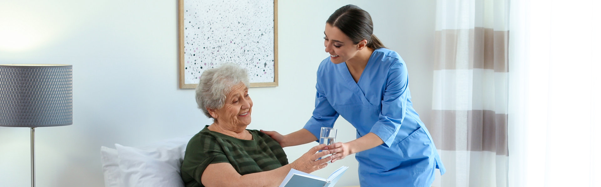 caregiver giving water to the senior woman