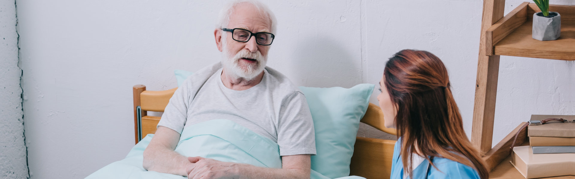 nurse and senior man in bed