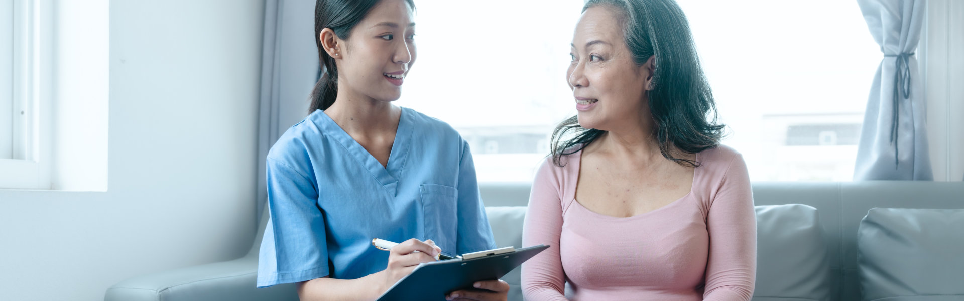 senior woman and caregiver holding a clipboard