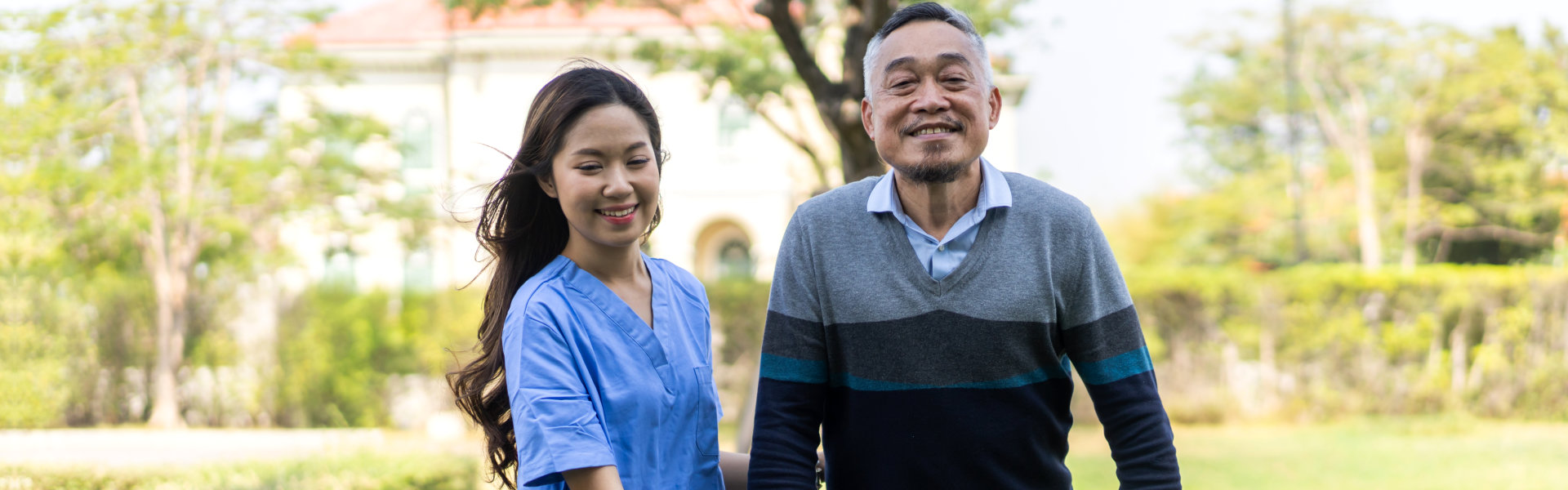 caregiver and senior man walking outside